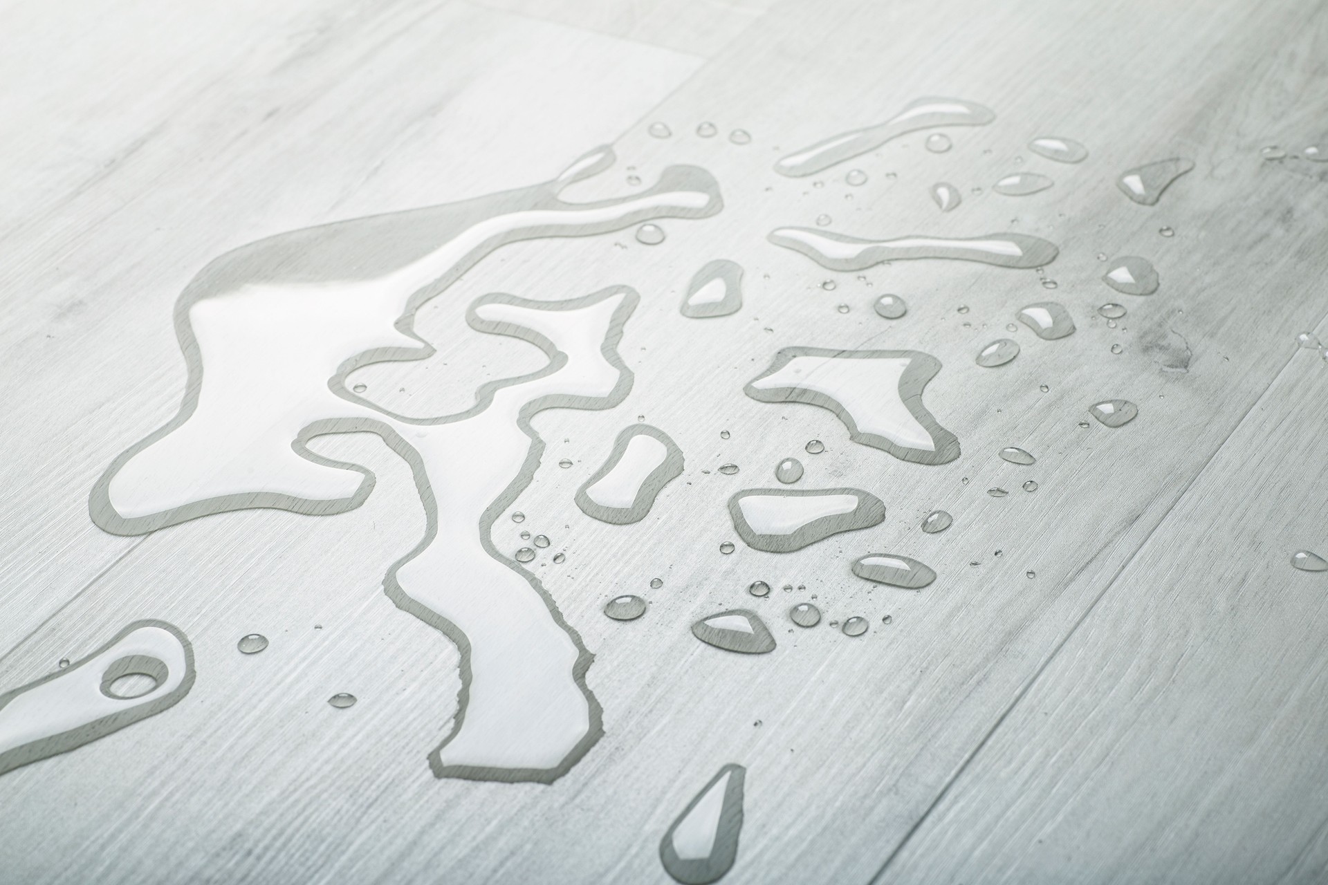 Water and moisture on the wooden parquet floor in the living room. Moisture protection for wooden floors and laminates